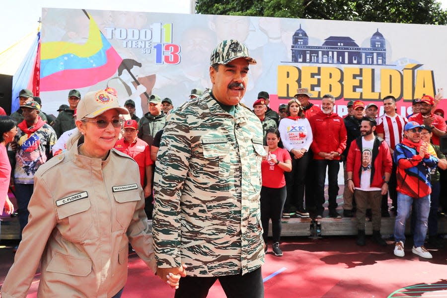 This handout picture released by the Venezuelan Presidency shows Venezuelan President Nicolas Maduro (C) and First Lady Cilia Flores arriving at a political rally in Caracas on April 13, 2024. Venezuelan President Nicolás Maduro proposed on Saturday a constitutional reform to establish life imprisonment and political disqualifications for life for corruption and treason crimes in the South American country, where the highest penalty is 30 years in prison. (Photo by ZURIMAC CAMPOS / Venezuelan Presidency / AFP)