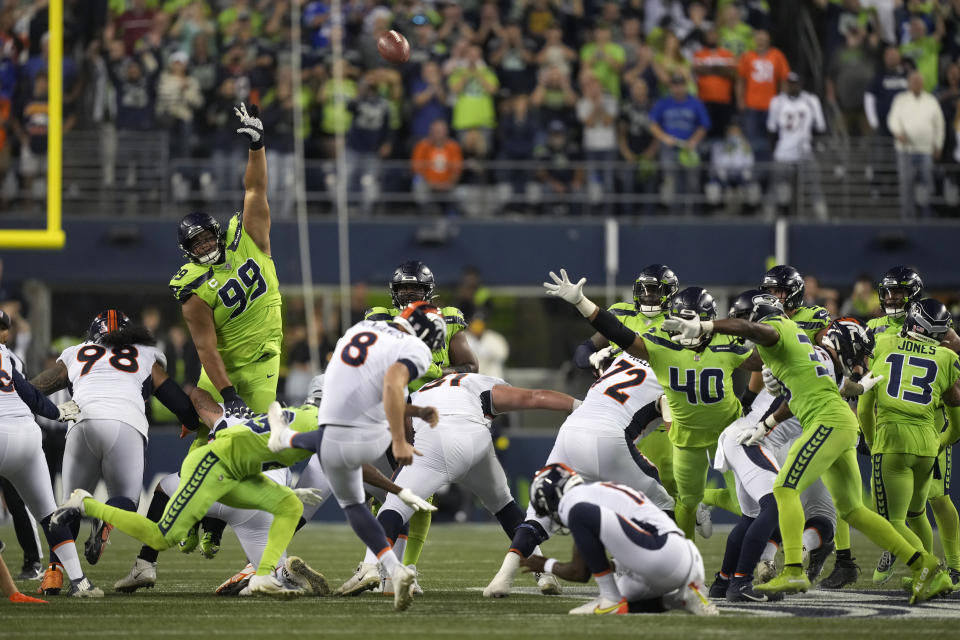 Denver Broncos place kicker Brandon McManus (8) attempts a field goal as Seattle Seahawks defensive tackle Al Woods (99) attempts the block during the second half of an NFL football game, Monday, Sept. 12, 2022, in Seattle. The kick went wide and the Seahawks won 17-16. (AP Photo/Stephen Brashear)