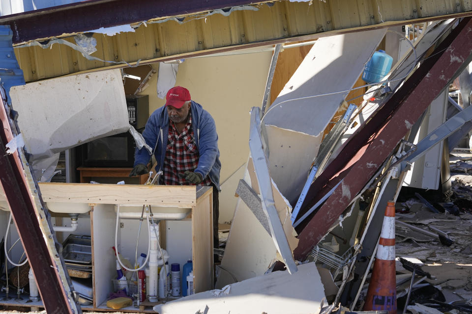 Timothy Turner looks for his belongings in the Community Baptist Church, Monday, Dec. 11, 2023 in Nashville, Tenn. The church was destroyed by severe storms that ripped through central Tennessee over the weekend. (AP Photo/George Walker IV)