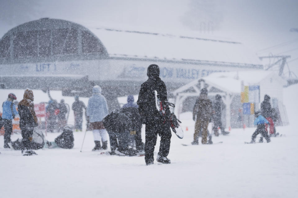 Snow falls on snowboarders and skiers on the Big Mountain Resort during a storm, Saturday, March 30, 2024, in Big Bear Lake, Calif. (Big Mountain Resort via AP)