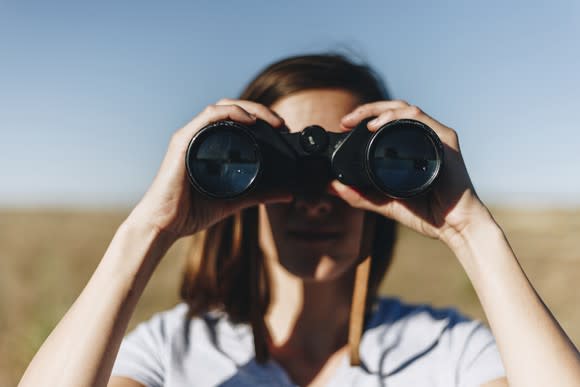 Woman looking through binoculars.