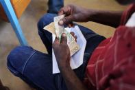 A Haitian man counts gourde notes distributed by the World Food Programme in Bainet