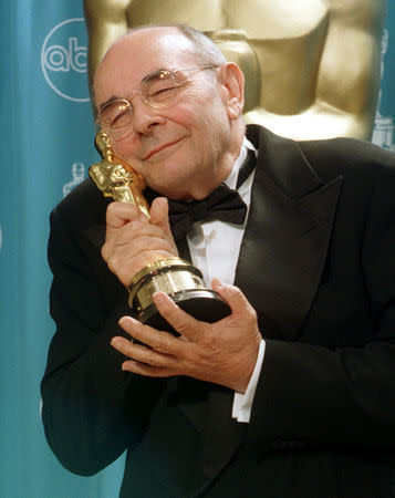 FILE PHOTO: Stanley Donen, director of the classic films "Singing In The Rain" and "American in Paris", hugs his Oscar backstage after receiving the honorary award for life-time achievement March 23 at the 70th Annual Academy Awards. - PBEAHUMAPAF/File Photo