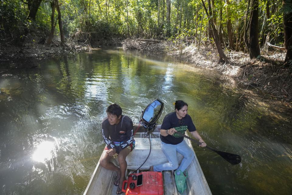 Mayta Juma, right, and her partner Puruem Uru-Eu-Wau-Wau ride a boat on the Assua River in the Juma Indigenous community, near Canutama, Amazonas state, Brazil, Saturday, July 8, 2023. Along with two sisters, Mayta leads and manages the Indigenous territory after the death of their father in 2021. (AP Photo/Andre Penner)