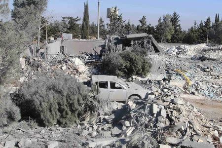 A damaged vehicle parks beside collapsed buildings after what activists said was a U.S.-led air strike on Kafar Joum village in West Aleppo countryside November 6, 2014. REUTERS/Stringer