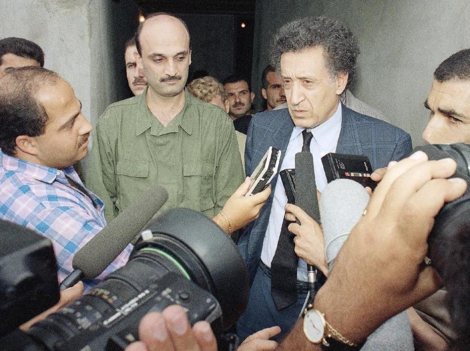 FILE - This is a Tuesday, July 17, 1990 file photo of Arab League Mediator Lakhdar Brahimi, right, as he talks to the media after his 90-minute meeting with Christian Lebanese forces militia Chieftain Samiar Geagea, left. Lakhdar Brahimi has seen faces like these before, barely able to remain in the same room, much less speak to each other. Lebanese, Afghans, Iraqis, now Syrians. Even, two decades ago, Algerians like himself. For days now, the veteran U.N. mediator has presided over peace talks intended to lead the way out of Syria's civil war. He brought President Bashar Assad's government and the opposition face to face for the first time on Saturday, Jan. 25, 2014, while still ensuring that they don't have to enter by the same door or address each other directly. He is 80. He is patient. (AP Photo/Eddy Tamerian, File)