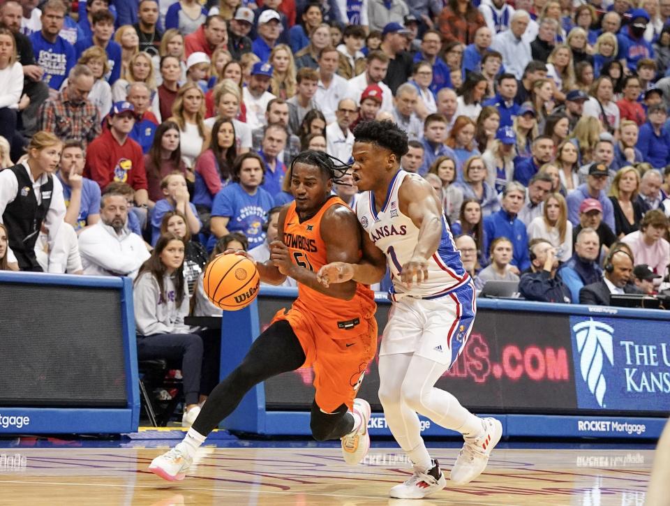 Oklahoma State guard John-Michael Wright (51) dribbles the ball as Kansas guard Joseph Yesufu (1) defends during the first half Saturday at Allen Fieldhouse.