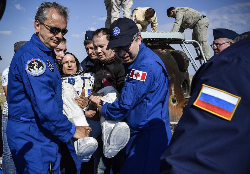 Ground personnel carry David Saint-Jacques of the Canadian Space Agency shortly after landing in a remote area outside Zhezkazgan, Kazakhstan, on June 25, 2019.