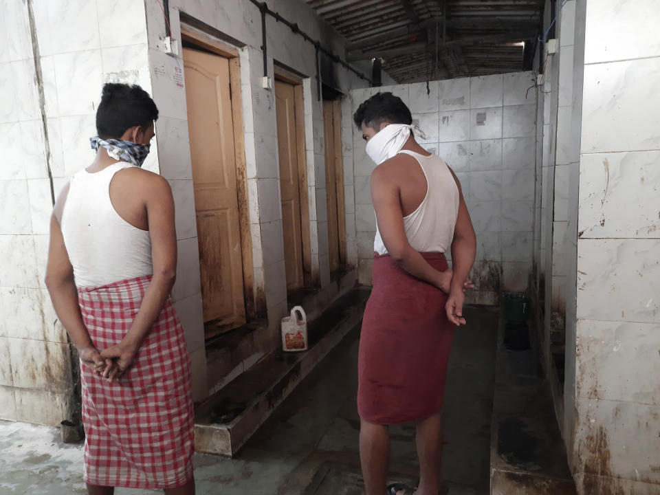 Residents wait in a queue to use a toilet complex in Dharavi, one of Asia's largest slums, in Mumbai, India, Tuesday, May 12, 2020. Dharavi has around 500 toilet complexes for almost a million residents, few having running water. Keeping the toilets disinfected has been a challenge for authorities in the days of the coronavirus. (Kunal Kanase via AP)