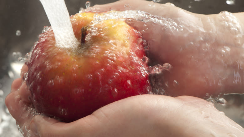 hands washing apple