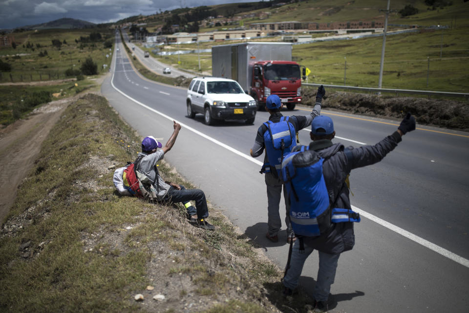 Migrantes venezolanos tratan de parar un auto para viajar hacia Bogotá, en Tunja, Colombia, el 6 de octubre de 2020. La pandemia ha convertido las carreteras sudamericanas en un territorio más hostil para los migrantes pobres que no tienen dinero para boletos de buses: los albergues siguen cerrados, los conductores son más reticentes a subirlos a sus vehículos y los residentes que temen contagiarse son menos propensos a ayudar con donaciones de comida. (AP Foto/Iván Valencia)