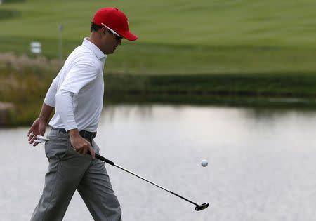 U.S. team member Zach Johnson picks up his ball on the ninth hole during their four ball matches of the 2015 Presidents Cup golf tournament at the Jack Nicklaus Golf Club in Incheon, South Korea, October 10, 2015. REUTERS/Toru Hanai