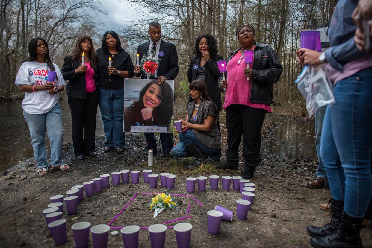 Danielle Locklear family members, (left to right) Karen McDonald, Darlene Heegel, Pastor Hester Fisher, Pastor James Simmons, Chena Simmons, Tana Bagget and Darcus Anderson at a Candle Light Memorial held in honor of 15- year-old Danielle Locklear on Wednesday, March 11, 2015, a year after she went missing. Family, friends and supporters met at the bridge over the South River in Autryville.