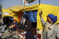 Sikh farmer sit at their make shift tents at Singhu, Delhi-Haryana border, camp for protesting farmers against three farm bills, in New Delhi, India, Wednesday, Jan. 27, 2021. Tens of thousands of farmers who stormed the historic Red Fort on India’s Republic Day are again camped outside the capital after the most volatile day of their two-month standoff left one protester dead and more than 300 police officers injured. (AP Photo/Manish Swarup)