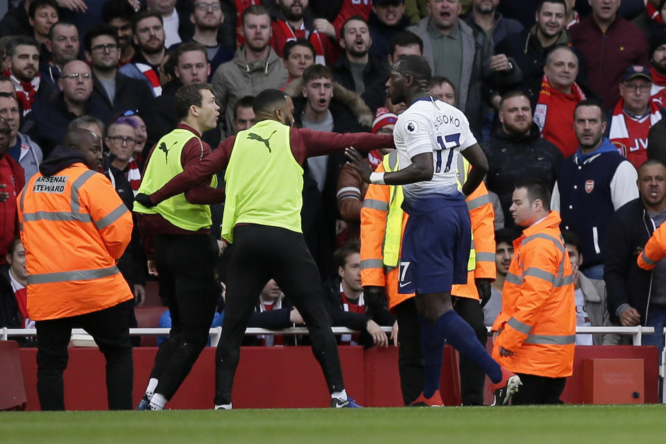 Tottenham's Moussa Sissoko, right, agrees with Arsenal's Stephan Lichtsteiner, left, after Tottenham's Harry Kane scored his side's opening goal from the penalty spot during the English Premier League soccer match between Arsenal and Tottenham Hotspur at the Emirates Stadium in London, Sunday Dec. 2, 2018. (AP Photo/Tim Ireland)
