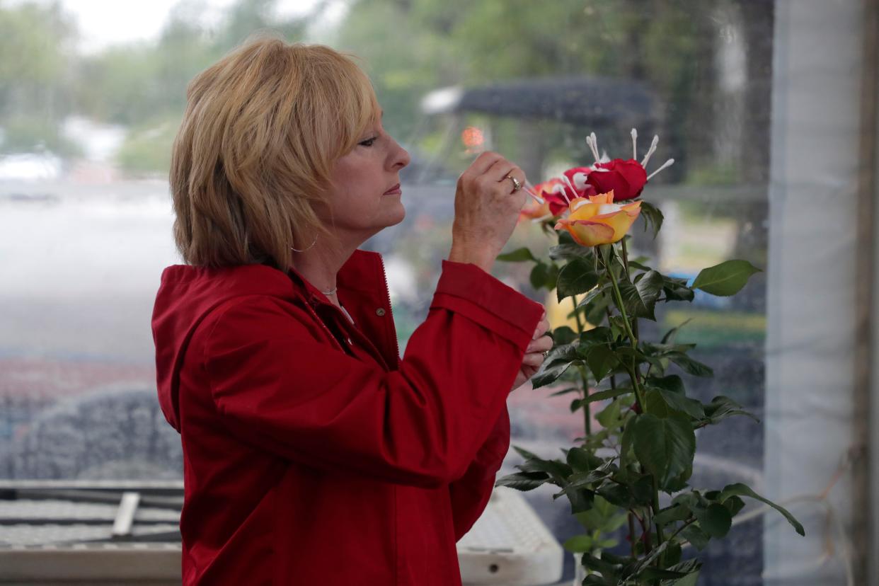 FILE - Donna Harrell places q-tips inside a rose to weigh down the petals and open up the bloom. Professional and novice rose growers prep their most beautiful blooms to show off at the Thomasville Rose Show and Festival Friday, April 26, 2019. The annual spring event returns April 26-27.