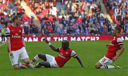 Arsenal's Per Mertesacker (L) celebrates his goal against Wigan Athletic with teammates Bacary Sagna (C) and Alex Oxlade-Chamberlain during their English FA Cup semi-final soccer match at Wembley Stadium in London April 12, 2014. REUTERS/Eddie Keogh