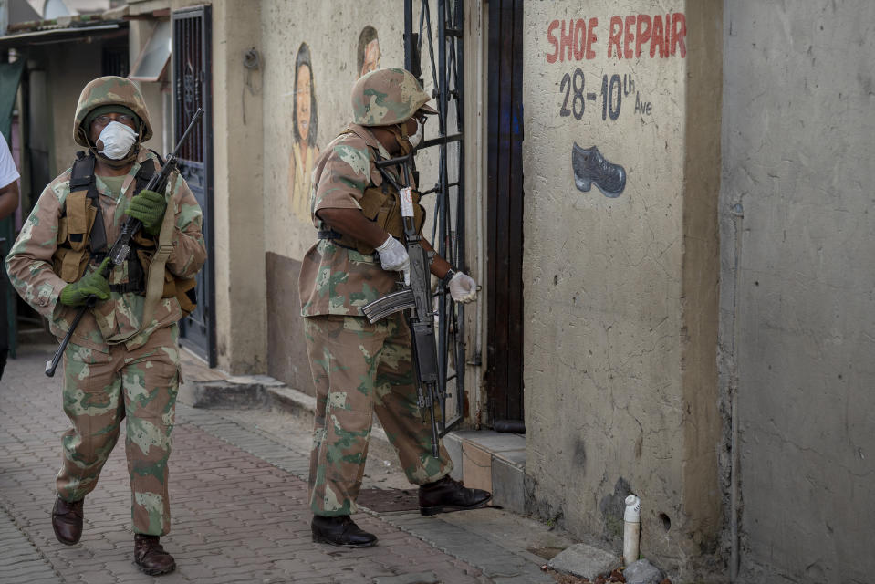 South African National Defense Forces patrol the densely populated Alexandra township east of Johannesburg Friday, March 27, 2020. South Africa went into a nationwide lockdown for 21 days in an effort to mitigate the spread to the coronavirus, but in Alexandra, many people were gathering in the streets disregarding the lockdown. The new coronavirus causes mild or moderate symptoms for most people, but for some, especially older adults and people with existing health problems, it can cause more severe illness or death.(AP Photo/Jerome Delay)