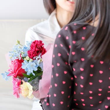 Woman-presenting-another-woman-with-a-bouquet-of-flowers_web