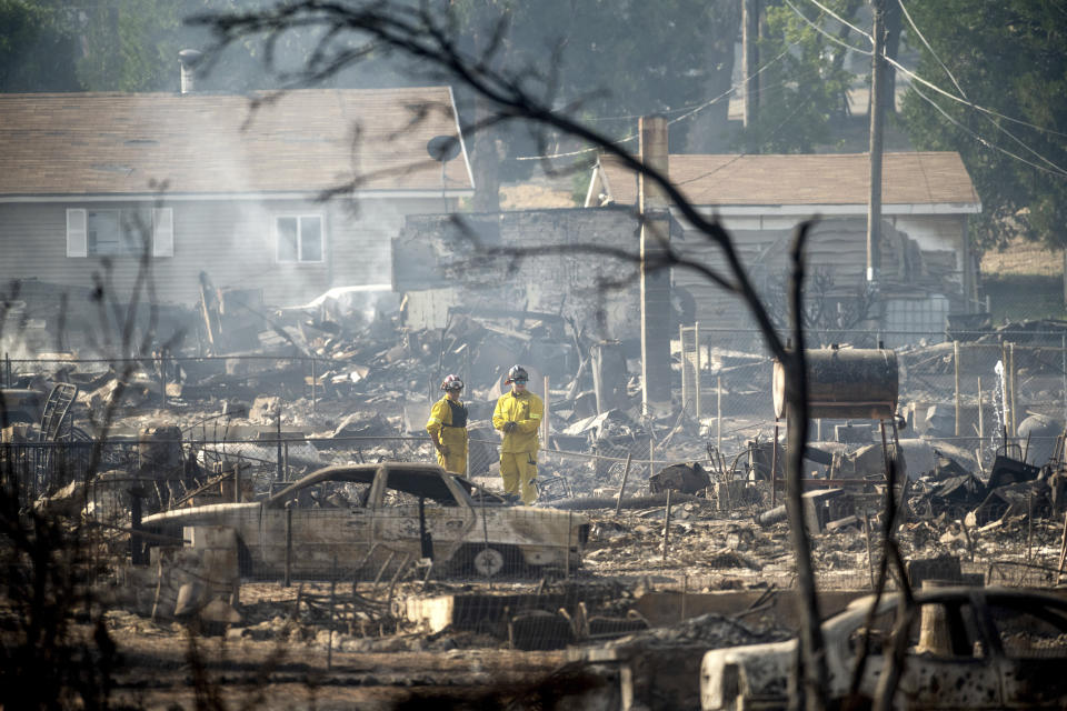 Firefighters survey homes on Wakefield Avenue destroyed by the Mill Fire on Saturday, Sept. 3, 2022, in Weed, Calif. (AP Photo/Noah Berger)