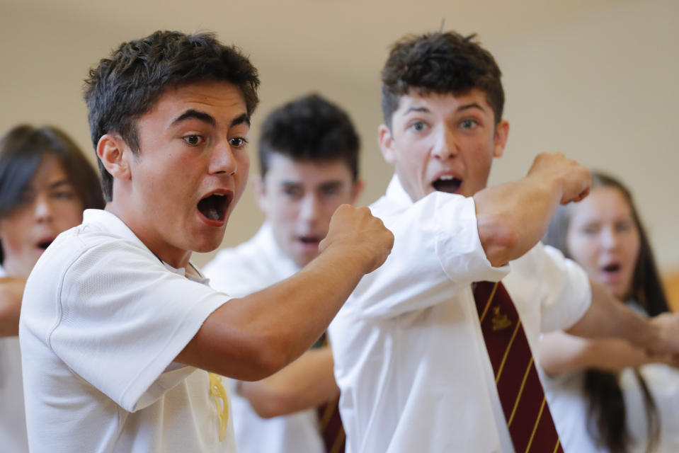 FILE - In this March 20, 2019, file photo, students perform the Haka during arrival of New Zealand's Prime Minister Jacinda Ardern, during a high school visit in Christchurch, New Zealand. Day after day, the students of Christchurch have gathered, feet smashing the ground in unison as they chant the words of their nation's indigenous people in an outpouring of grief and love and support. In the aftermath of a white supremacist's deadly shooting spree on two mosques on March 15, the young people of Christchurch have found solace in an old tradition: a Maori ceremonial dance called the haka. (AP Photo/Vincent Thian, File)