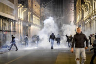 Smoke billows as clashes broke out during a protest against the government restriction measures to curb the spread of COVID-19 in Turin, Italy, Monday, Oct. 26, 2020. Protesters turned out by the hundreds in Italian several cities and towns on Monday to vent anger, sometimes violently, over the latest anti-COVID-19 rules, which force restaurants and cafes to close early, shutter cinema, gyms and other leisure venues. In the northern city of Turin, demonstrators broke off from a peaceful protest and hurled smoke bombs and bottles at police in the city square where the Piedmont regional government is headquartered. (Claudio Furlan/LaPresse via AP)