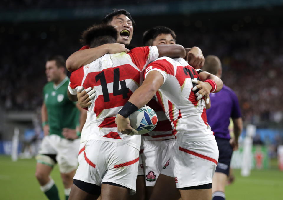 Japan's Kenki Fukuoka, right, is congratulated by teammates after scoring a try during the Rugby World Cup Pool A game at Shizuoka Stadium Ecopa between Japan and Ireland in Shizuoka, Japan, Saturday, Sept. 28, 2019. (AP Photo/Jae Hong)