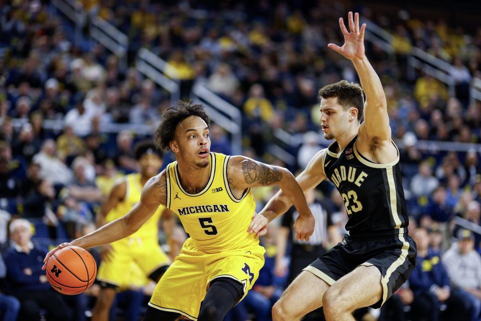 Terrance Williams II of the Michigan Wolverines looks to pass the ball while being guarded by Camden Heide of the Purdue Boilermakers in the first half of a game at Crisler Arena on Sunday, Feb. 25, 2024, in Ann Arbor, Michigan.