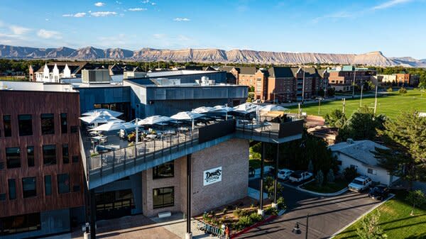 A view of the Devil’s Kitchen patio, with the Colorado Mesa University and mountains in the background.