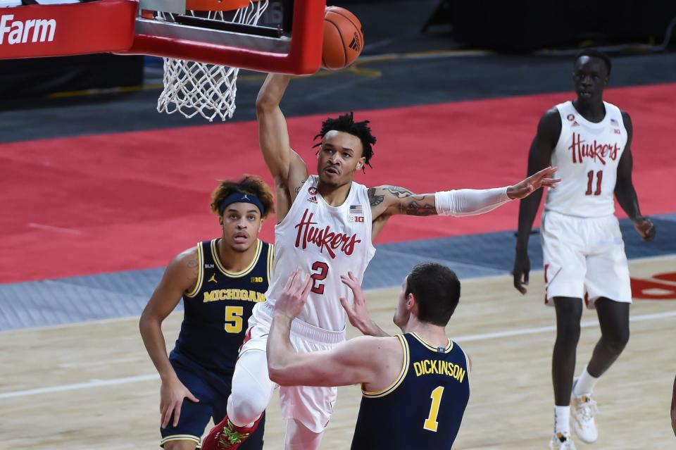 Cornhuskers guard Trey McGowens (2) drives against Michigan center Hunter Dickinson (1) and forward Terrance Williams II (5) in the first half at Pinnacle Bank Arena on Friday, Dec. 25, 2020.