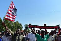 <p>Residents of Nyang’oma village in Kogelo wave US flags as they gather by the side of the road to wait for former US President, Barak Obama to arrive on July 16, 2018 for the opening of the Sauti Kuu Resource Centre, founded by his half-sister, Auma Obama at Kogelo in Siaya county, western Kenya. – Obama is in the East African nation for the first time since he left the US presidency and met with President Uhuru Kenyatta and opposition leader Raila Odinga in Nairobi. (Photo: Tony Karumba/AFP/Getty Images) </p>