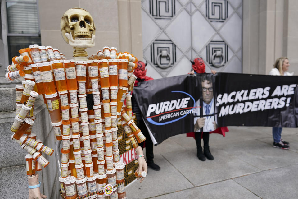 FILE - "Pill Man" made by Frank Huntley of Worcester, Mass., from his opioid prescription pill bottles, is displayed during a protest by advocates for opioid victims outside the Department of Justice, Dec. 3, 2021, in Washington. OxyContin maker Purdue Pharma, the family that owns it and lawyers for thousands of parties with claims against it are getting ready to work on a new settlement after the U.S. Supreme Court rejected the last one. (AP Photo/Carolyn Kaster, file)