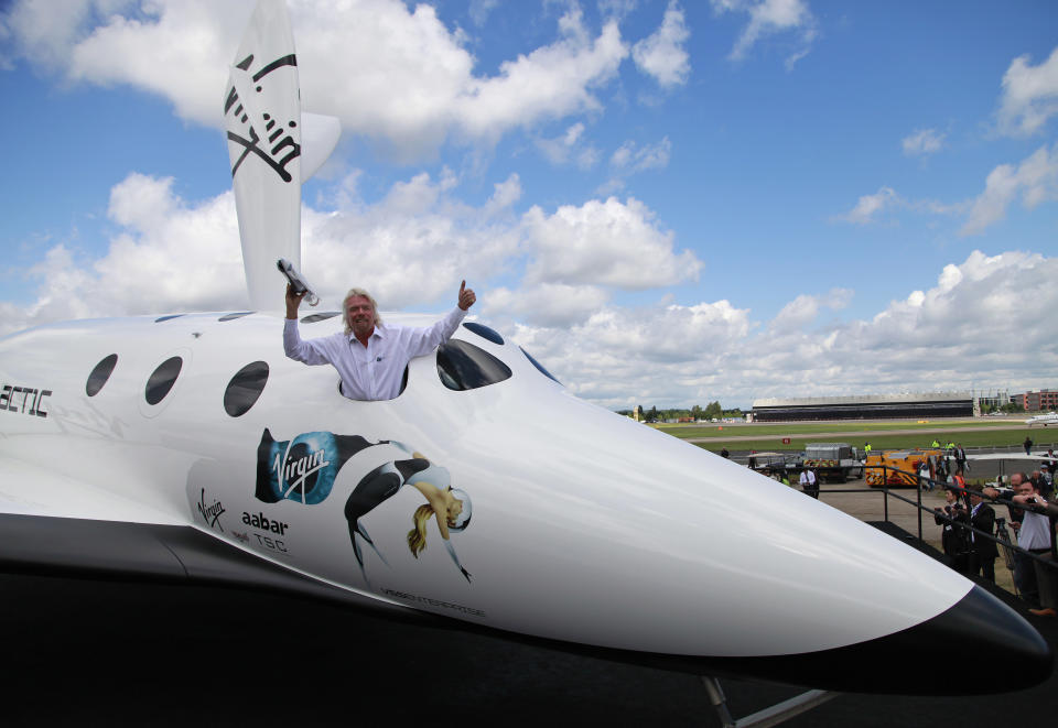 British billionaire Richard Branson poses for the photographers in the window of a replica of the Virgin Galactic, which according to the company will be the world’s first commercial spaceline, at the Farnborough International Airshow in Farnborough, England, Wednesday, July 11, 2012.Virgin Galactic announced “LauncherOne,” a new air-launched rocket specifically designed to deliver small satellites into orbit. Commercial flights of the new orbital launch vehicle are expected to begin by 2016, Virgin Galactic aims to offer frequent and dedicated launches at the world’s lowest prices. (AP Photo/Lefteris Pitarakis)