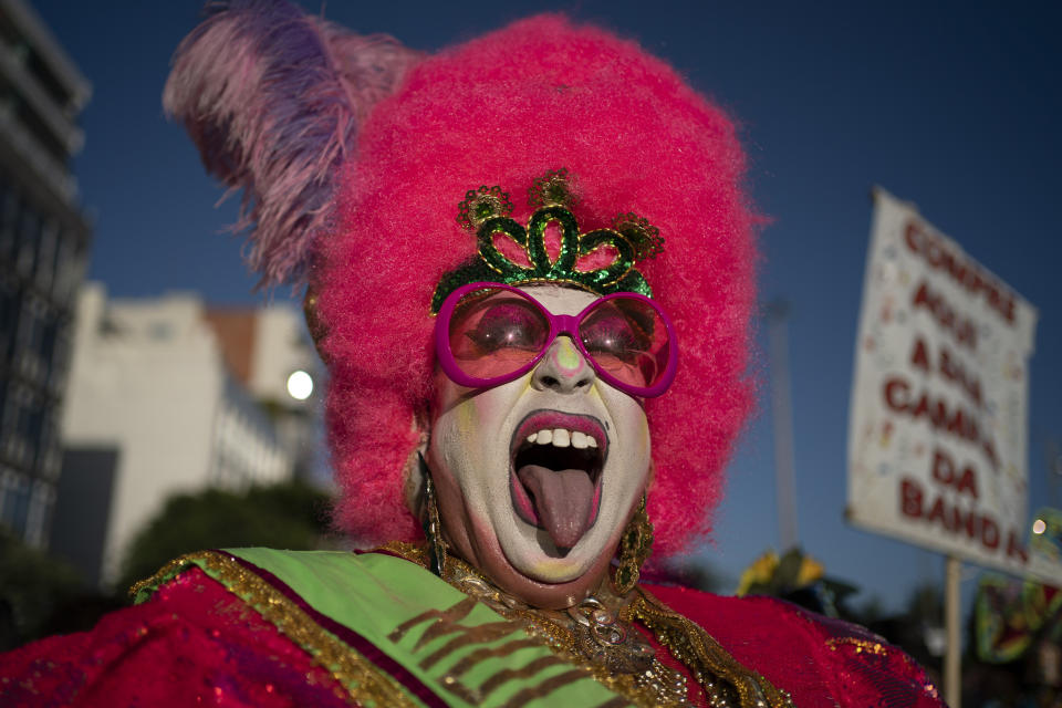 A drag queen playfully sticks out his tongue during the "Banda de Ipanema" street party in Rio de Janeiro, Brazil, Saturday, Feb. 8, 2020. Thousands have started attending the popular street parties, two weeks ahead of the world's famous carnival festival that begins on Feb 21. (AP Photo/Leo Correa)