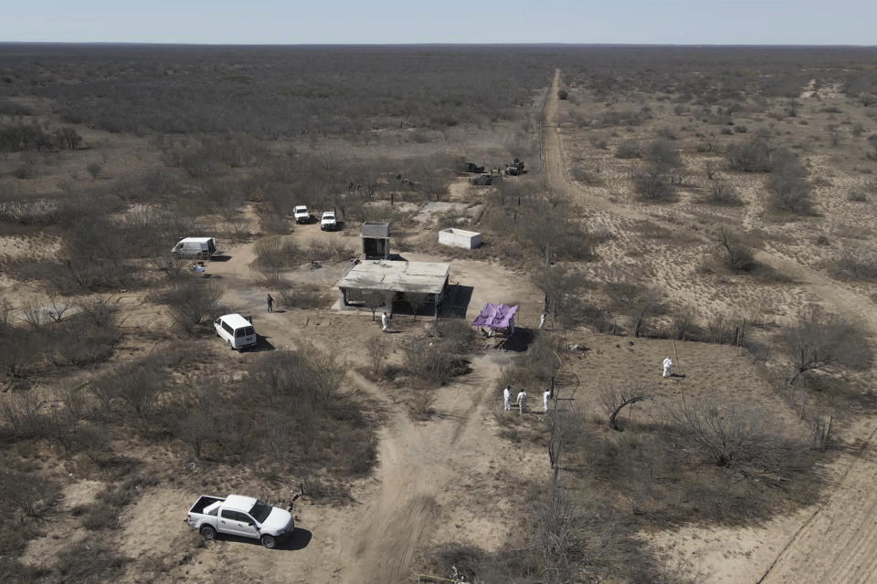 Forensic technicians excavate a field where uncounted of human bone fragments are spread across 75,000 square feet of this desert scrubland, on the outskirts of Nuevo Laredo, Mexico, Tuesday, Feb. 8, 2022. When the team first arrived to what is referred to as a cartel “extermination site”, they had to clear brush and pick up human remains over the final 100 yards just to reach the squat, ruined house where bodies were ripped apart and incinerated. (AP Photo/Fernanda Pesce)