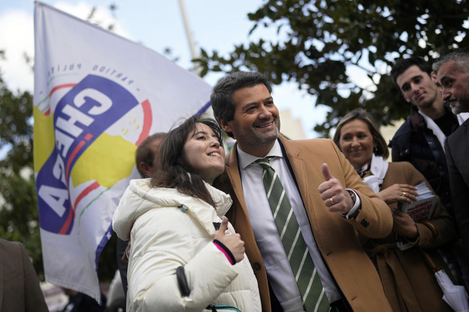 Carolina Pereira, 21, poses for a photo with Andre Ventura, right, leader of populist radical right party Chega (Enough) during a Chega campaign action in Almada, south of Lisbon, Feb. 23, 2024. Pereira says that she can't find a job, the work on offer pays badly, and young people from her city of Almada have been forced to seek work abroad. (AP Photo/Armando Franca)