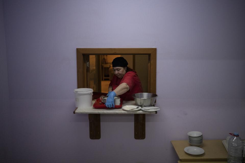 A cook clears plates at the Barentsburg's school cafeteria in Barentsburg, Norway, Saturday, Jan. 7, 2023. The children's choir from the Lutheran church in the Arctic archipelago of Svalbard traveled three hours each way by boat to mark Orthodox Christmas with the 40 children in Barentsburg, a village owned by Russia's Arctic mining company in the remote Norwegian territory. (AP Photo/Daniel Cole)