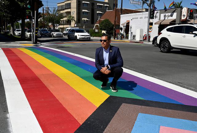 <p>Brittany Murray/MediaNews Group/Long Beach Press-Telegram via Getty</p> Robert Garcia, then the mayor of Long Beach, California, poses on a new Progress Pride crosswalk in the city on June 30, 2022