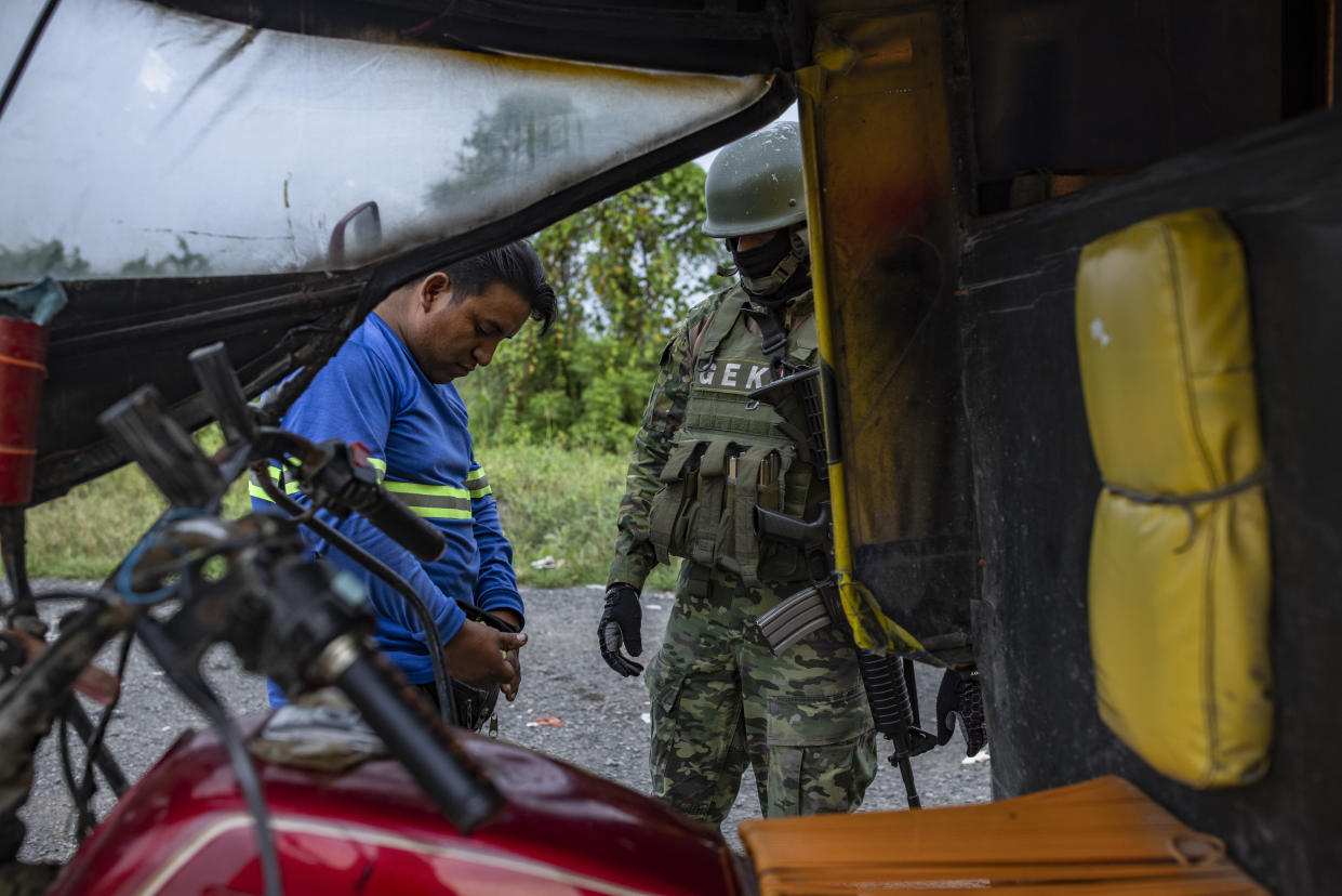 Hombres detenidos durante una redada policial en las afueras de Guayaquil. (Victor Moriyama/The New York Times)
