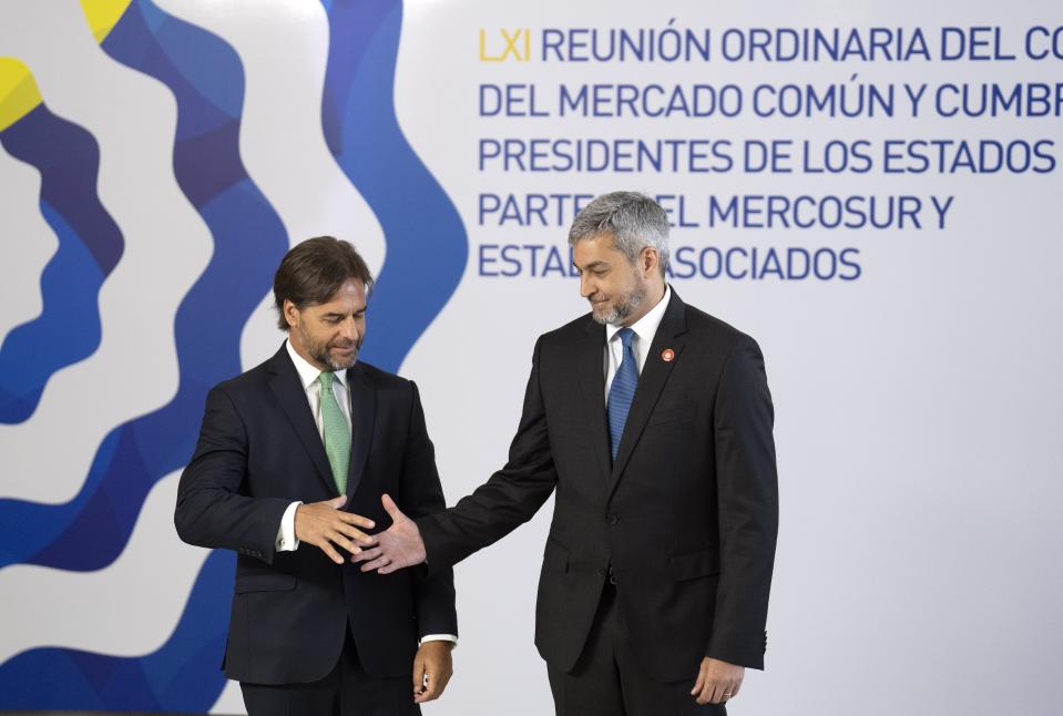 Uruguay's President Luis Lacalle Pou, left, greets Paraguay's President Mario Abdo at the Mercosur trade bloc summit in Montevideo, Uruguay, Tuesday, Dec. 6, 2022. (AP Photo/Matilde Campodonico)