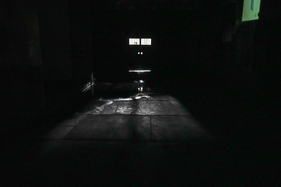 Lights trickles in through a tunnel access door at the National Stadium that was used as a prison and place of torture during the Augusto Pinochet dictatorship, in Santiago, Chile, Saturday, Aug. 19, 2023. Pinochet died in 2006 without being convicted of any crimes. The Documentation and Archive Foundation of the Vicariate of Solidarity continues to seek justice through the use of their archive that preserves 47,000 instances of human rights violations during the Pinochet regime. (AP Photo/Esteban Felix)