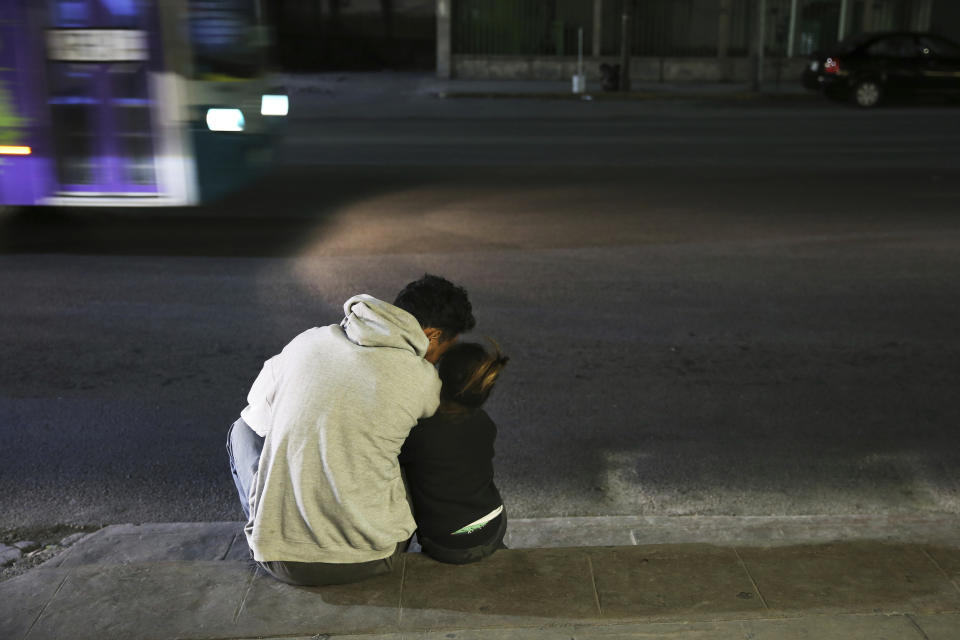 In this July 18, 2019 photo, a migrant father and daughter sit on the sidewalk after getting off a bus that brought them all the way from Nuevo Laredo to Monterrey, Mexico, Thursday, July 18, 2019. The group was placed on the bus by Mexican migration authorities, arriving in this northern Mexican city late at night and left them to fend for themselves with no support on housing, work or schooling for children, who appear to make up about half the group. (AP Photo/Marco Ugarte)