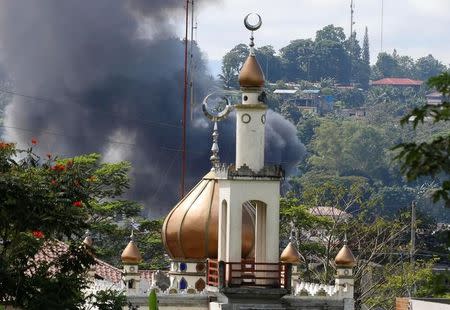 Smoke billows at the site of fighting between government soldiers and Maute group, near a mosque in Marawi City in southern Philippines May 30, 2017. REUTERS/Erik De Castro
