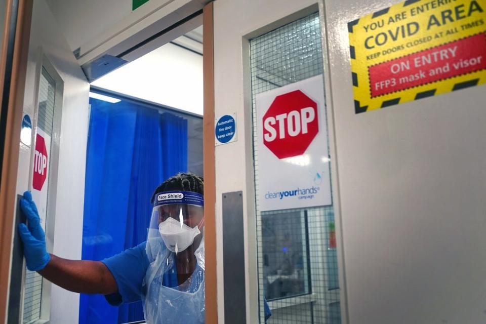 A member of staff wearing PPE walks through a ward for Covid patients at King’s College Hospital, in south east London (Victoria Jones/PA) (PA Wire)