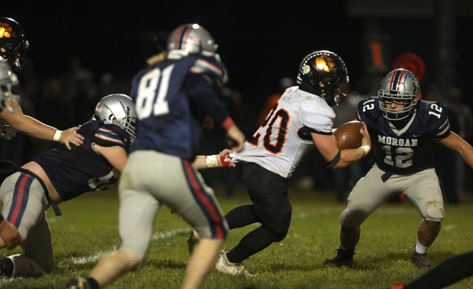 New Lexington's Hunter Rose fights for yardage against Morgan.