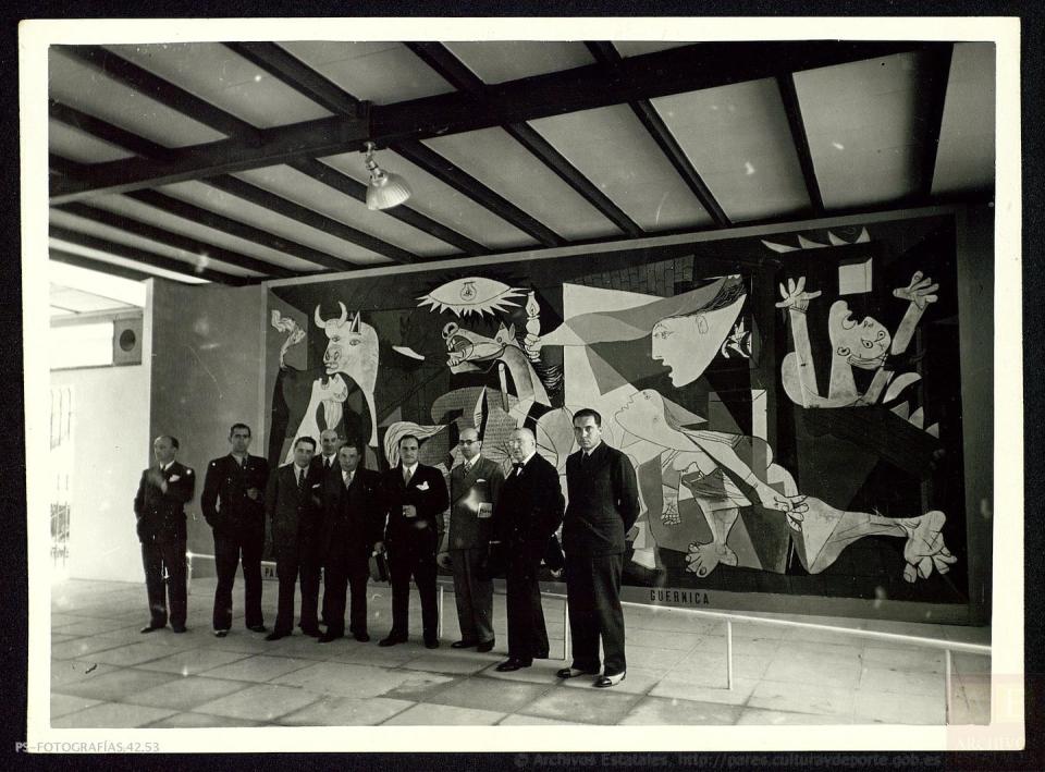 Varias personalidades contemplan el Guernica de Picasso durante su visita al pabellón de España en la Exposición Internacional de París, entre ellos el Comisario General del pabellón español, José Gaos, el comisario del gobierno vasco, José María Uzelai, el presidente de Euzkadi, José Antonio Aguirre, y varios miembros del gobierno español. <a href="http://pares.mcu.es/ParesBusquedas20/catalogo/description/12898045" rel="nofollow noopener" target="_blank" data-ylk="slk:MCD. Archivos Estatales (España);elm:context_link;itc:0;sec:content-canvas" class="link ">MCD. Archivos Estatales (España)</a>