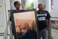 FILE - In this Sept. 3, 2020, file photo, Joe Prude, right, brother of Daniel Prude, and Daniel's nephew Armin, stand with a picture of Daniel Prude in Rochester, N.Y. In a decision announced Tuesday, Feb. 23, 2021, a grand jury voted not to charge officers shown on body camera video holding Daniel Prude down naked and handcuffed on a city street last winter until he stopped breathing. Joe Prude said Wednesday, Feb. 24 he had viewed police body camera footage showing what happened after officers caught up with Daniel Prude, naked on a frigid March night, as irrefutable proof of a crime. (AP Photo/Ted Shaffrey, File)