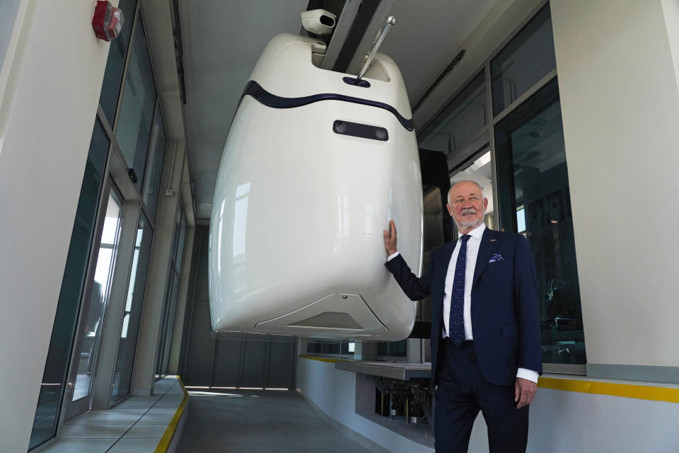 Anatoli Unitsky, the creator of the string rail technology used by the pod-transport firm uSky, stands in front a test pod as he speaks to journalists in Sharjah, United Arab Emirates, Thursday, Oct. 28, 2021. The futuristic transit solution is being promoted by a Belarusian firm that hopes to secure contracts here in the near future. However, uSky has ties back to a Belarusian investment firm called SkyWay that has seen multiple nations in Europe and elsewhere issue warnings to investors that they "may be involved in a scam." (AP Photo/Jon Gambrell)