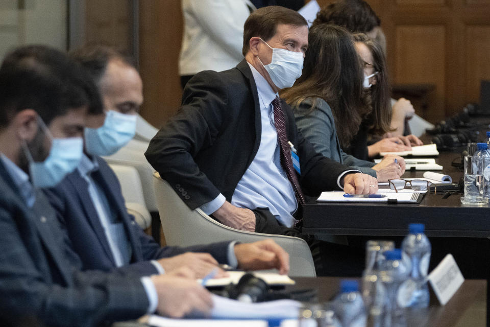 Iran's agent Tavakol Habibzadeh, second left, and US agent Richard Visek, in focus, and delegation members wait for judges to enter the International Court of Justice, the United Nations' top court, which issued its judgment in a dispute between Iran and the United States over frozen Iranian state bank accounts worth some $2 billion, in The Hague, Netherlands, Thursday, March 30, 2023. (AP Photo/Peter Dejong)