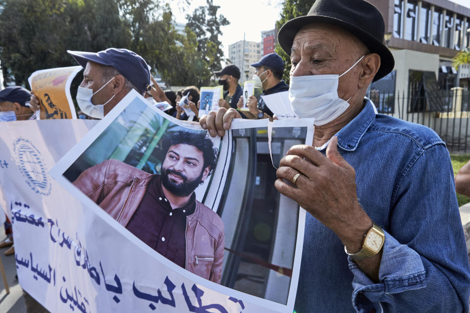 Supporters protest in front of the Casablanca Courthouse, in Casablanca, Morocco, Tuesday, Sept. 22, 2020, on the first day of the hearing of journalist and activist Omar Radi. The arrest of journalist Omar Radi follows numerous summons following a police investigation into suspicion of receiving funds linked to foreign intelligence. The investigation came after rights group Amnesty International accused Morocco of using Israeli-made spyware to snoop on its phone. (AP Photo/Abdeljalil Bounhar)